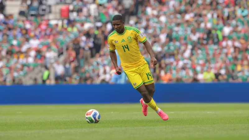 Mbekezeli Mbokazi : la révélation sud-africaine de la Coupe du Monde Mbekezeli Mbokazi en action lors d'un match de la Coupe du Monde, portant le maillot de l'Afrique du Sud, concentré et déterminé sur la pelouse.