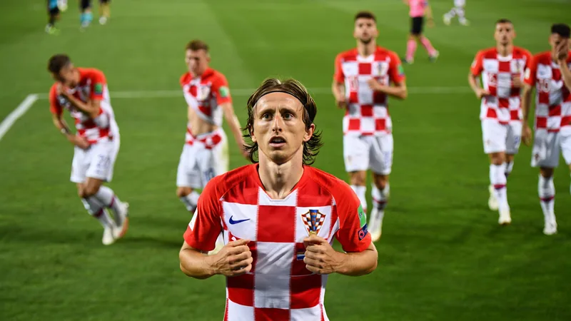 Luka Modric en action avec le maillot de la Croatie, cheveux longs flottant au vent, sur un terrain de football lors d'un match de Coupe du monde.