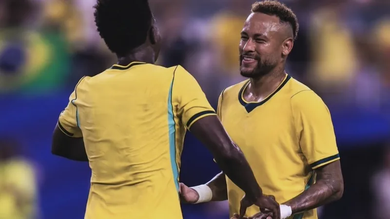 Neymar et Vinicius Jr en tenue du Brésil, souriant et se regardant sur un terrain de football lors d'un entraînement en Coupe du Monde.