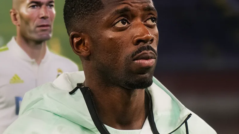 Ousmane Dembélé souhaite voir Zidane sélectionneur des Bleus Ousmane Dembélé en tenue du Paris Saint-Germain lors d'un match, souriant et regardant vers la caméra, avec le logo du PSG en arrière-plan.