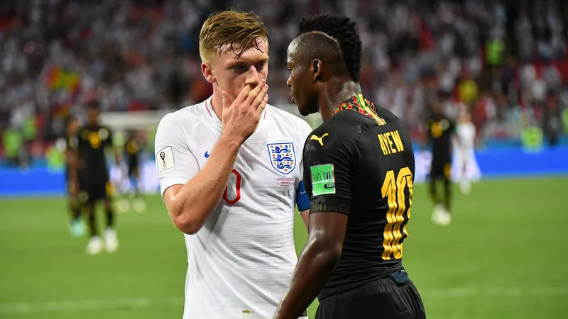 Jude Bellingham discutant avec Jordan Ayew sur le terrain, tous deux souriants, sans animosité, lors d'un match de la Coupe du Monde 2026.