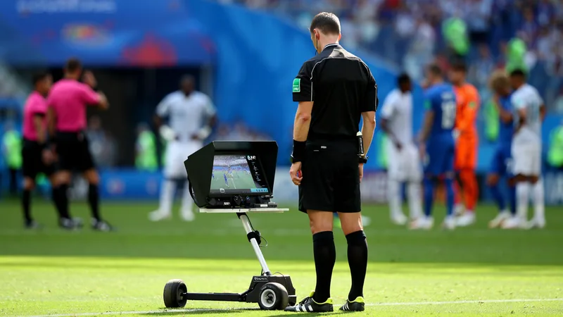VAR : Coupe du monde vs Premier League, une utilisation différente Arbitre consultant le moniteur VAR lors d'un match de Coupe du monde, avec des joueurs attendant la décision. — latest news and analysis.