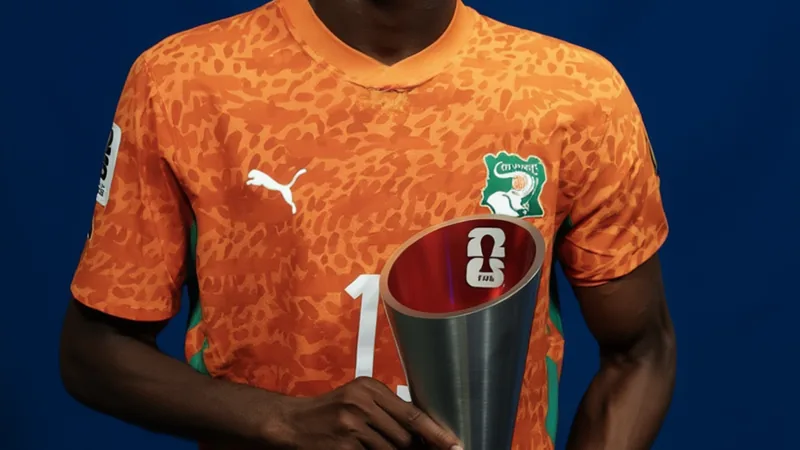 Yan Diomande, jeune joueur ivoirien de 19 ans, célébrant après un match de Coupe du Monde, portant le maillot orange de la Côte d'Ivoire.