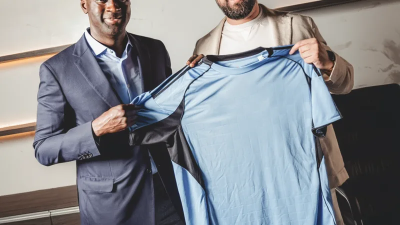 Yaya Touré nommé entraîneur du Slovan Bratislava — Football World Cup Yaya Touré en costume, souriant, tenant un maillot du Slovan Bratislava devant le logo du club — latest news and analysis.