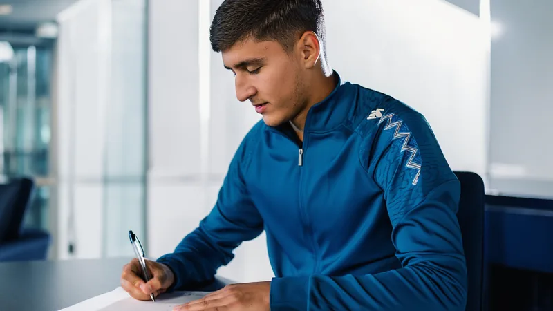 Abdukodir Khusanov prolonge à Manchester City jusqu'en 2031 Abdukodir Khusanov en tenue de Manchester City posant avec un ballon sur la pelouse de l'Etihad Stadium, souriant devant les tribunes.