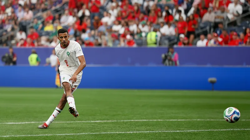 Azzedine Ounahi marque son premier but en Coupe du Monde 2026 Azzedine Ounahi célébrant son but avec Achraf Hakimi sur un terrain de football, portant le maillot du Maroc, avec des supporters en arrière-plan.