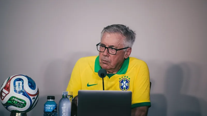 Carlo Ancelotti confirme qu'il reste sélectionneur du Brésil Carlo Ancelotti en costume, debout sur la touche d'un terrain de football, regardant le match avec une expression déterminée, drapeau brésilien en