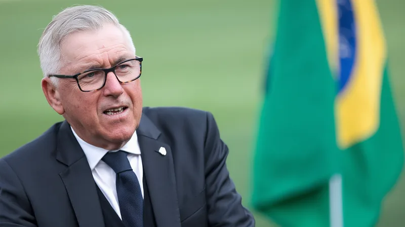 Carlo Ancelotti, entraîneur du Brésil, en costume, regardant le terrain lors d'un match de football, l'air pensif. — latest news and analysis.