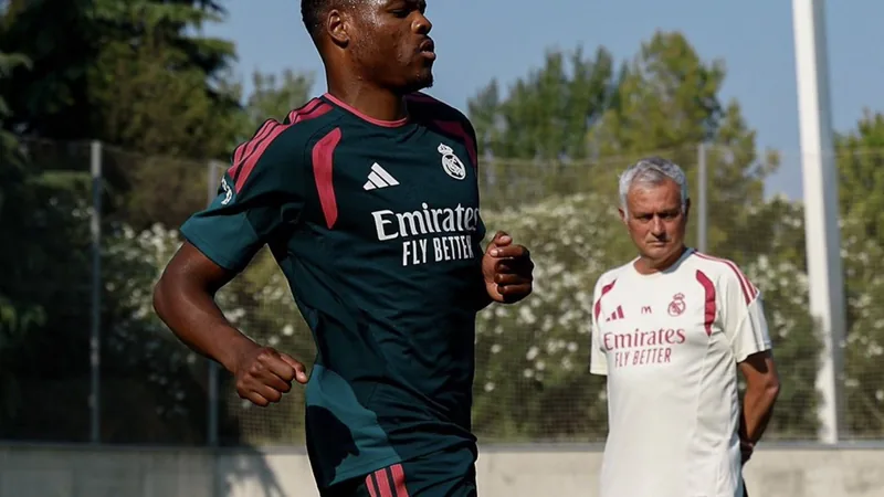 Denzel Dumfries en tenue du Real Madrid, souriant, tenant le maillot blanc du club devant le logo du Santiago Bernabéu. — latest news and analysis.