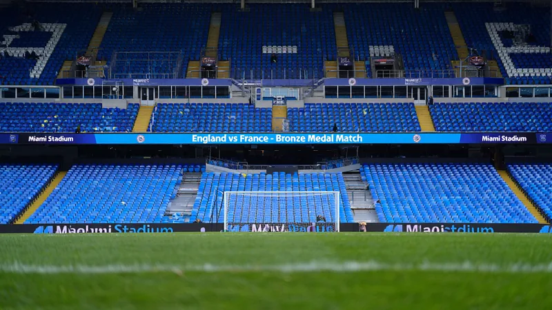 Des milliers de billets encore disponibles pour Angleterre-France Vue aérienne du Hard Rock Stadium de Miami illuminé la nuit, avec des sièges vides et des écrans géants affichant le match Angleterre-France.