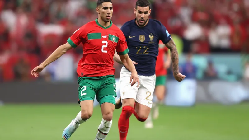 France - Maroc : les Lions de l'Atlas veulent leur revanche en quarts Joueurs marocains célébrant une victoire au Boston Stadium, avec le phare illuminé en arrière-plan et un écran géant affichant le score.