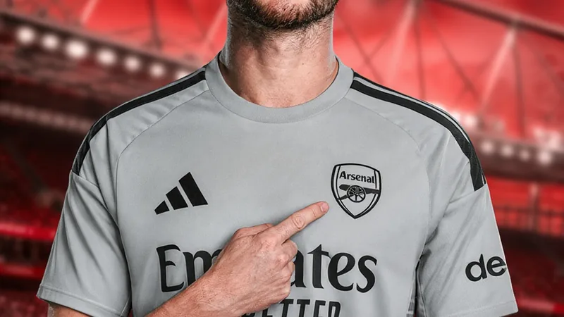 Illan Meslier à Arsenal : accord trouvé, visite médicale réussie Illan Meslier en tenue d'Arsenal lors de sa signature, souriant devant le logo du club à l'Emirates Stadium. — latest news and analysis.