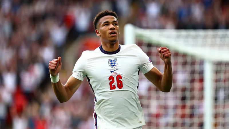 L'Angleterre arrache une victoire épique contre le Mexique et file en Joueurs anglais célébrant leur victoire sur le terrain, avec Jude Bellingham levant les bras au milieu de ses coéquipiers en liesse.