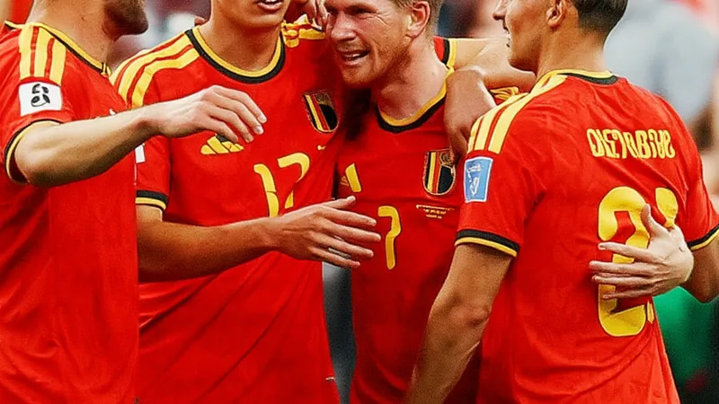 Belgique en quarts de finale de la Coupe du Monde — Football World Joueurs belges célébrant leur qualification pour les quarts de finale de la Coupe du Monde sur le terrain, avec des drapeaux belges en arrière-plan.