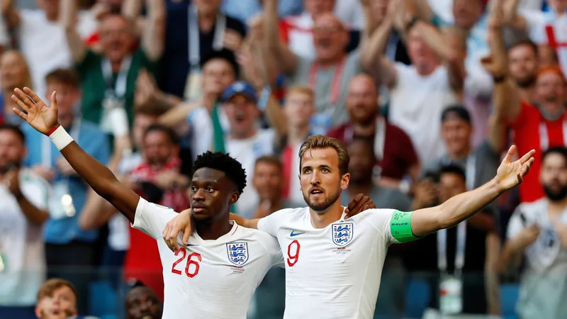 Harry Kane et Jude Bellingham célèbrent un but ensemble, bras tendus, devant des supporters anglais en délire au stade Azteca de Mexico.
