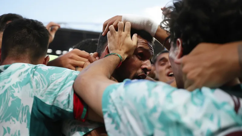 Les plus belles photos de la 22e journée des éliminatoires de la Un joueur célébrant un but sous les projecteurs d'un stade, avec des supporters agitant des drapeaux en arrière-plan lors d'un match des