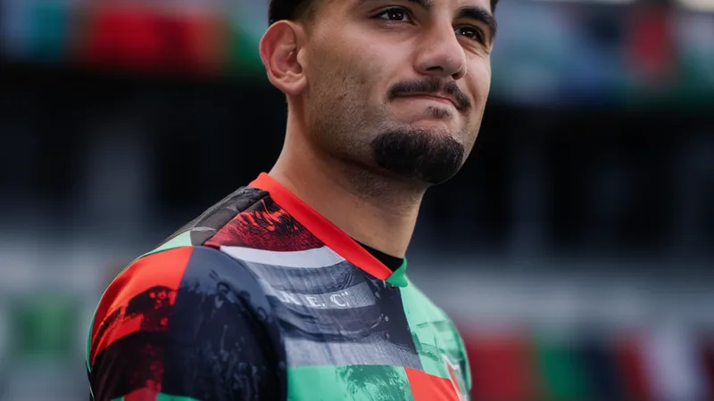 Lille finalise le transfert de Başar Önal pour 14,5 millions d'euros Un joueur de football en tenue du LOSC Lille posant avec un maillot du club sur un fond vert, souriant devant un micro lors de sa présentation