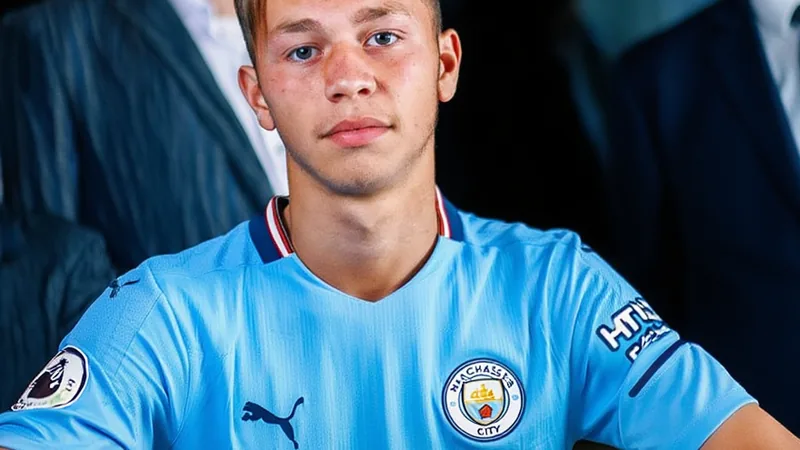 Mathys Detourbet prêté à l'AS Monaco par Manchester City — Football Mathys Detourbet en tenue de l'AS Monaco, souriant devant le stade Louis-II à Monaco, avec le maillot rouge et blanc du club monégasque