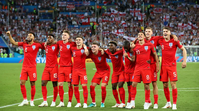 Joueurs de l'équipe d'Angleterre célébrant une victoire en Coupe du monde, avec le maillot blanc et le drapeau anglais en arrière-plan.