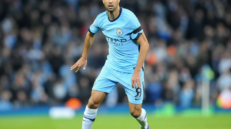 Rodri, milieu de terrain de Manchester City, en action lors d'un match, portant le maillot bleu ciel, souriant après une victoire.