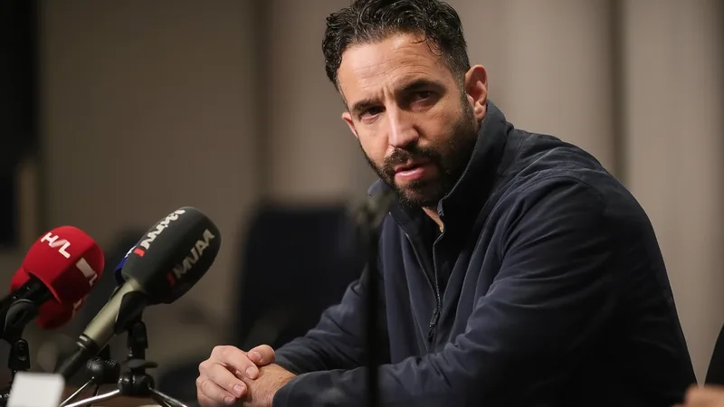 Rúben Amorim en costume, debout sur le bord du terrain de San Siro, parlant à Christian Pulisic en tenue d'entraînement de l'AC Milan.