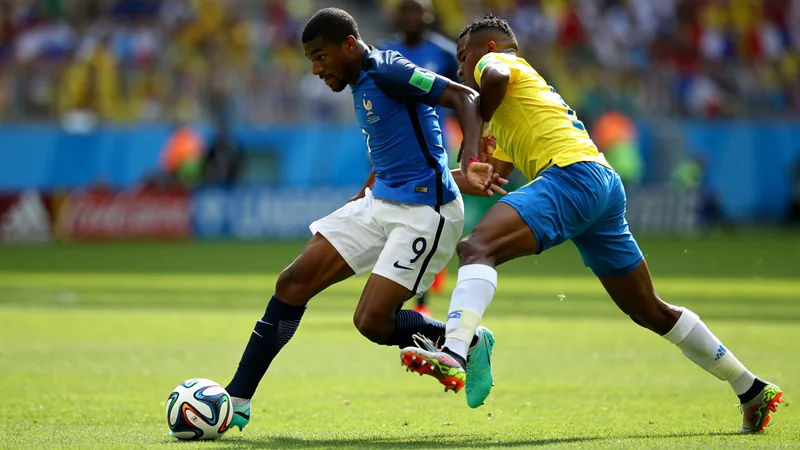 Michael Olise : l'ascension unique du prodige français — Football Michael Olise en action avec le maillot de l'équipe de France lors d'un match de Coupe du monde, dribblant un adversaire.