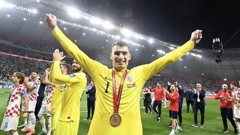 Barcelone vise Livaković — Football World Cup News Dominik Livaković, gardien croate, en action lors d'un match avec le Fenerbahçe, portant son maillot jaune et noir, dans un stade rempli de