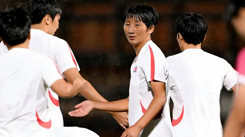 Joueuses de football en action lors d'un match de la Coupe du Monde U20 féminine, avec le drapeau polonais en arrière-plan.