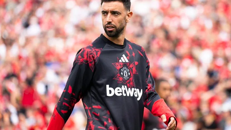 Galatasaray vise Bruno Fernandes, MU refuse — Football World Cup News Bruno Fernandes en maillot rouge de Manchester United, le ballon au pied, sur la pelouse d'Old Trafford sous les projecteurs.