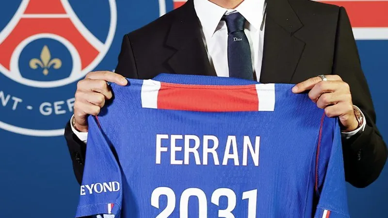 PSG : Ferran Torres signe pour 50 M€ — Football World Cup News Ferran Torres en tenue du PSG, souriant, posant avec le maillot du club au Parc des Princes, devant les caméras lors de sa présentation officielle.