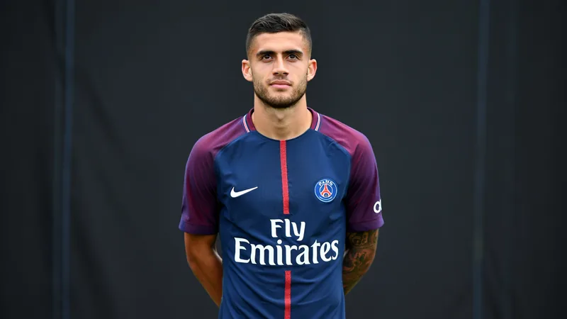 Lucas Digne signe au PSG — Football World Cup News Lucas Digne en maillot du PSG, souriant, posant avec le maillot du club au Parc des Princes, avec les couleurs bleu et rouge en arrière-plan.