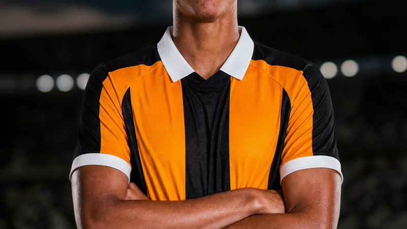 Lucas Herrington, jeune milieu de terrain australien, posant avec le maillot de Hull City lors de sa signature, devant le stade du club.