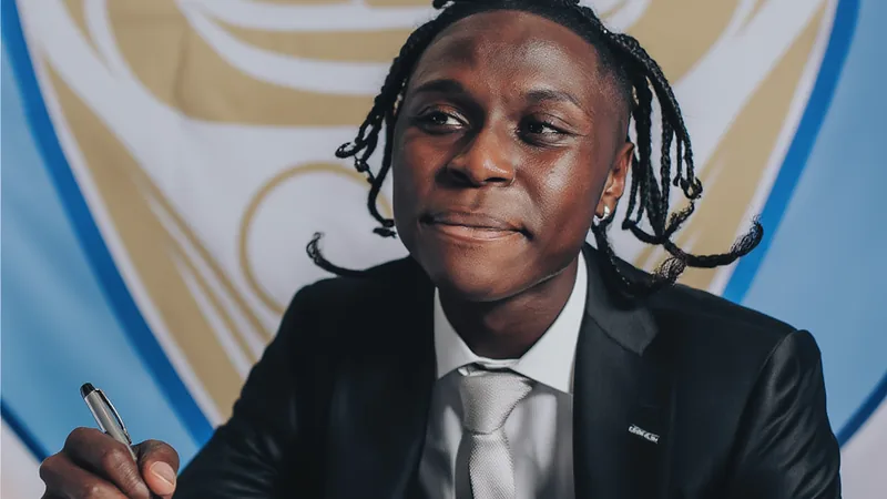 Manchester City recrute Heaven Kilwa — Football World Cup News Un jeune footballeur portant le maillot de Manchester City, dribblant un ballon sur un terrain d'entraînement, avec le logo du club en arrière-plan.