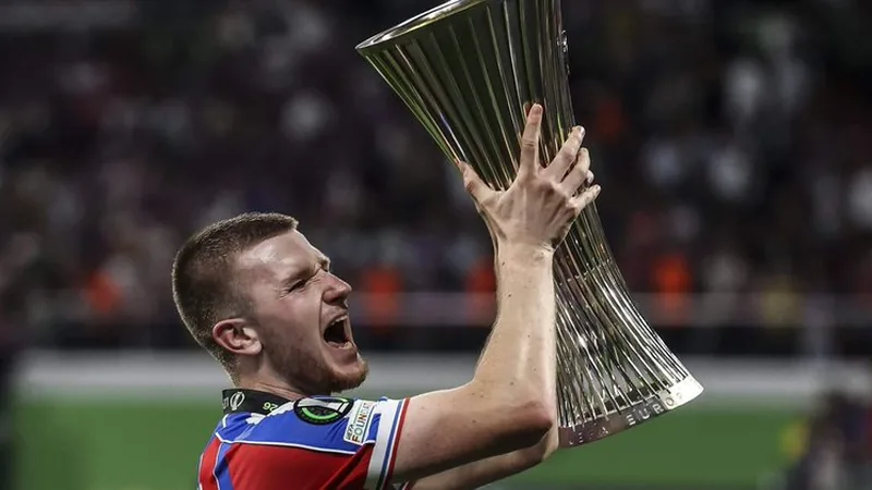 Adam Wharton en action lors d'un match de Premier League, portant le maillot de Crystal Palace, au milieu de la pelouse d'un stade anglais.