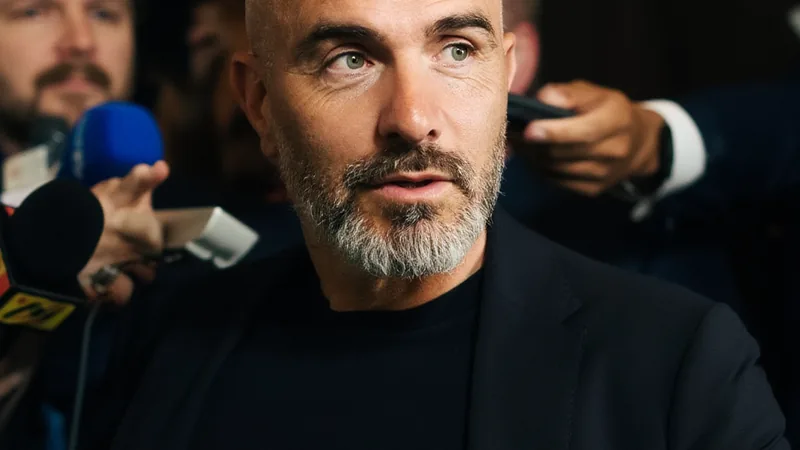 Avenir de Marmoush : Maresca s'exprime — Football World Cup News Enzo Maresca en conférence de presse, parlant de l'avenir d'Omar Marmoush à Chelsea, avec le logo du club en arrière-plan.