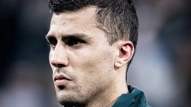 Rodri absent du Community Shield, Barcelone accélère — Football World Rodri, milieu de terrain de Manchester City, en action lors d'un match, portant le maillot bleu ciel, avec le logo du club visible.