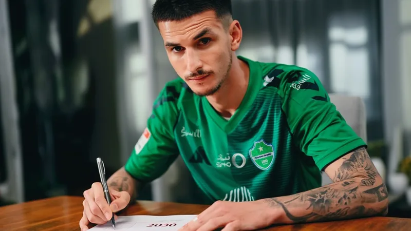 Roger Ibañez prolonge à Al Ahli jusqu'en 2030 — Football World Cup Roger Ibañez, défenseur brésilien, souriant en maillot vert et blanc d'Al Ahli, célébrant sa prolongation de contrat sur le terrain.