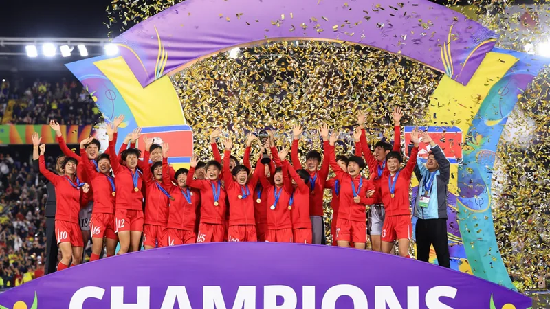 Trophée de la Coupe du Monde U-20 féminine sur un terrain de football, avec des joueuses célébrant en arrière-plan. — latest news and analysis.