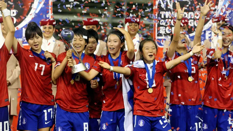 Coupe du Monde U-17 2010 : la revanche de la Corée du Sud — Football Joueuses de la Corée du Sud célébrant leur victoire à la Coupe du Monde U-17 2010, avec le trophée, sur la pelouse du Hasely Crawford Stadium à