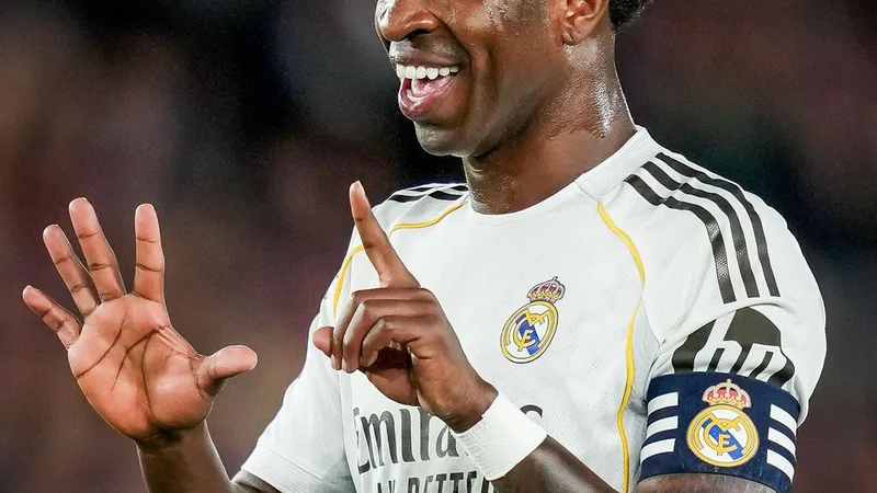 Vinicius Jr prolonge à Madrid jusqu'en 2032 — Football World Cup News Vinicius Jr souriant en tenue du Real Madrid, brandissant un maillot avec le numéro 7, devant le stade Santiago Bernabéu à Madrid.