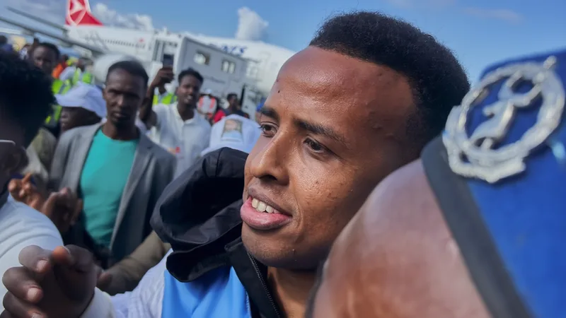 Árbitro somali negado nos EUA é recebido como herói — Football World Multidão no Aeroporto de Mogadíscio recebe árbitro Mohamed Ali com faixas e bandeiras da Somália, em clima de celebração e apoio.