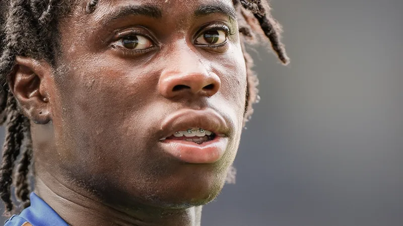 Jovem jogador Jeremy Monga com uniforme do Leicester City em campo de futebol, sorrindo, com estádio ao fundo — latest news and analysis.