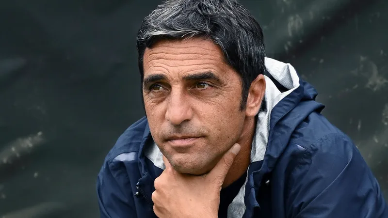 Tony d'Amico, novo diretor da AS Roma, em traje formal, posando ao lado do logotipo do clube em um escritório moderno. — latest news and analysis.