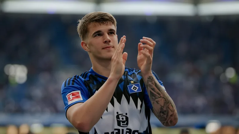 Jovem jogador de futebol croata Luka Vuskovic em campo com a camisa do Tottenham, durante partida da Premier League, em estádio lotado.
