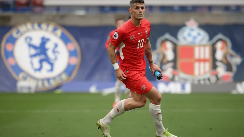 Granit Xhaka, meio-campista suíço, vestindo a camisa do Sunderland durante uma partida noturna no Estádio da Luz, em Lisboa, com a torcida ao fundo.