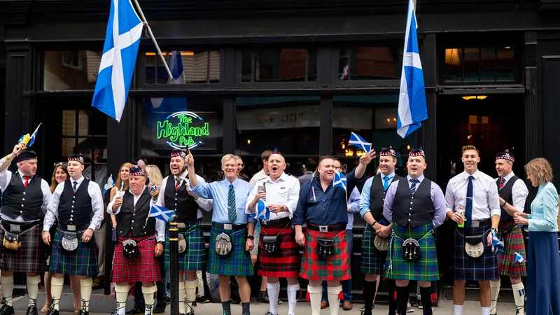 Exército Tartan 'trouxe nova vida' ao menor estado dos EUA — Football Torcedores escoceses do Exército Tartan vestidos de kilts e com bandeiras escocesas em frente a um bar em Providence, Rhode Island, durante a Copa do