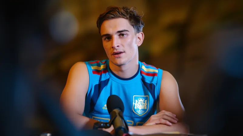 Gavi, meio-campista do Barcelona, sorrindo durante entrevista, com camisa do clube e fundo do estádio Camp Nou. — latest news and analysis.