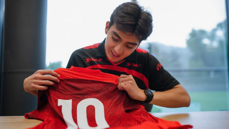 Jovem jogador mexicano Gilberto Mora segurando a camisa 10 do Tijuana em um estádio, com o gramado ao fundo. — latest news and analysis.