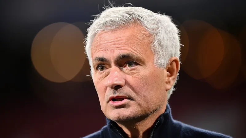 José Mourinho assina contrato e retorna ao Real Madrid — Football José Mourinho sorrindo com o uniforme do Real Madrid em um estádio, segurando um contrato, com o logotipo do clube ao fundo.