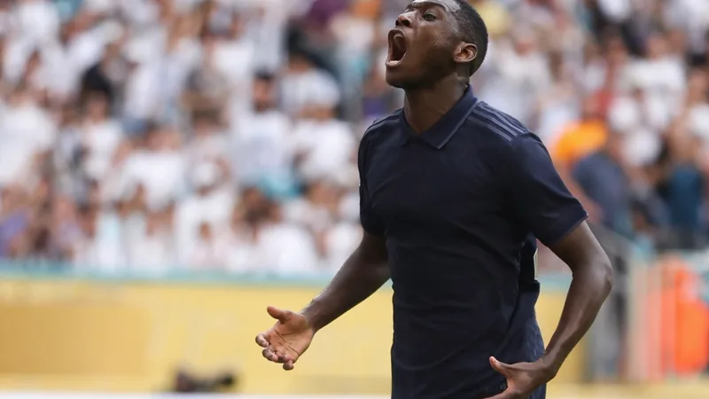 Randal Kolo Muani com a camisa do PSG durante uma partida, em um estádio lotado, sob luzes noturnas. — latest news and analysis.
